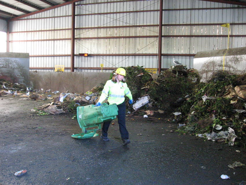 Anita hauls the green bin out of the mix